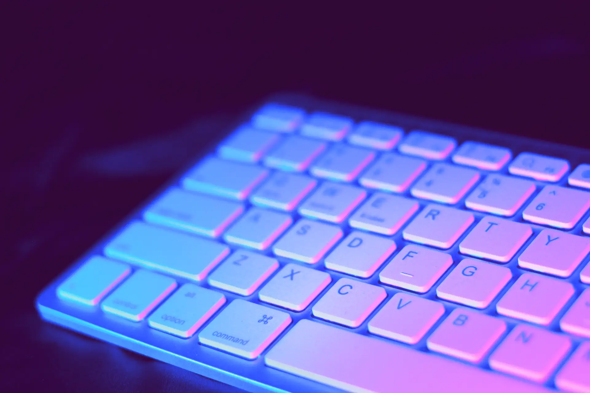 Neon pink and blue light on a white keyboard