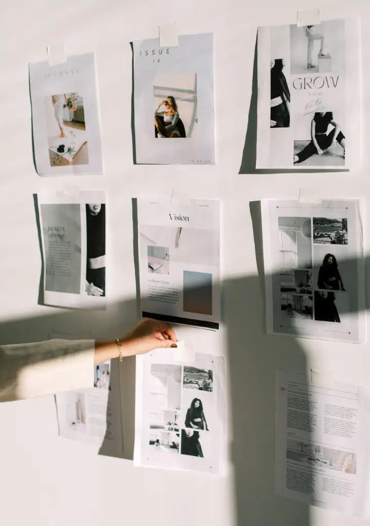Web designer placing printed web design mockups on wall gallery